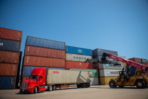 Industrial warehouse aisle with stacked pallets and machinery